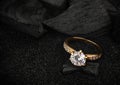 jewelry ring witht big diamond on dark coal and black sand background, soft focus Royalty Free Stock Photo