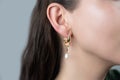 Jewelry shop. Girl model demonstrating stylish earrings. Fashionable jewelry. Royalty Free Stock Photo