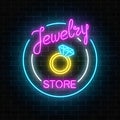 Jewelry store glowing neon signboard on dark brick wall background. Bijou shop advertisement shining sign.