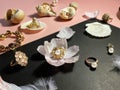 Jewelry white pearl gold rings on a black background with pink opal seashell rose petals and feathers concept woman accessory bac