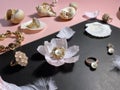 Jewelry white pearl gold rings on a black background with pink opal  seashell rose petals and feathers concept woman accessory bac Royalty Free Stock Photo