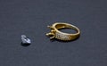 Jewelry work, gold ring with a diamond, preparation for installing a stone on a ring, dark background