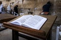 Jewish bible - Torrah on table on blurred background of praying Jews and wailing western wall. Israel. Jerusalem