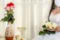 A Jewish bride, a fragment of her face before a chuppa ceremony during a pandemic, wearing a medical mask and a bouquet Royalty Free Stock Photo