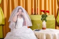 Jewish bride in a lush white dress, her face covered with a veil, crying before the chupa ceremony does not want to get