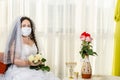 A Jewish bride sits in a synagogue by a stlik before a chuppa ceremony during a pandemic, wearing a medical mask and a Royalty Free Stock Photo