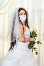 A Jewish bride in a synagogue before a chuppa ceremony during a pandemic, wearing a medical mask and a bouquet of Royalty Free Stock Photo