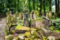 Krakow, Poland - 18 July 2016: Old Jewish cemetery with tombs overgrown with moss and grass and tall trees