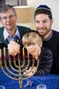 Jewish family lighting Chanukah menorah Royalty Free Stock Photo