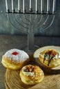 Jewish holiday Hanukkah background with menorah - traditional candelabra with candles and donuts