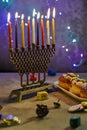 Jewish holiday Hanukkah background. A traditional dish is sweet donuts. Hanukkah table setting a candlestick with candles and