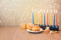 Jewish holiday Hanukkah celebration with menorah over bokeh background. Retro filter effect