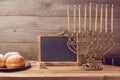 Jewish holiday Hanukkah celebration with vintage menorah and chalkboard with copy space