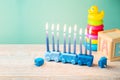 Jewish holiday Hanukkah concept with cute menorah on wooden table. Nursery decor and children room background