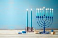 Jewish holiday Hanukkah concept with menorah, candles and dreidel on wooden table. Background for greeting card or banner Royalty Free Stock Photo