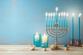 Jewish holiday Hanukkah concept with menorah, candles and dreidel on wooden table. Background for greeting card or banner Royalty Free Stock Photo