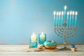 Jewish holiday Hanukkah concept with menorah, candles and dreidel on wooden table. Background for greeting card or banner Royalty Free Stock Photo
