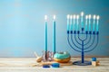 Jewish holiday Hanukkah concept with menorah, candles and traditional donut on wooden table. Background for greeting card or Royalty Free Stock Photo