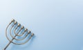 Jewish holiday Hanukkah concept. Top view of goldren menorah on pastel blue background