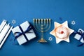 Jewish holiday Hanukkah concept with traditional jelly donut, menorah, candles and gift boxes. Flat lay, top view Royalty Free Stock Photo
