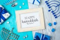 Jewish holiday Hanukkah greeting card with photo frame, menorah, gift box and spinning top on wooden table