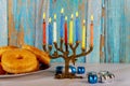 Jewish holiday Hanukkah with menora, donuts and dreidels