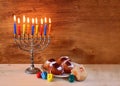 Jewish holiday Hanukkah with menorah, doughnuts over wooden table. retro filtered image Royalty Free Stock Photo