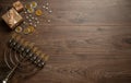 Jewish holiday Hanukkah with menorah, dreidels (spinning top) shiny coins and on a woden background.