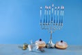Jewish holiday Hanukkah with menorah, traditional Candelabra, donut and dreidel, spinning top.