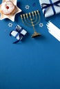 Jewish holiday Hanukkah poster design. Flat lay gold menorah, traditional donut with jam, gift boxes, candles, confetti on blue Royalty Free Stock Photo