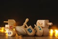 jewish holiday Hanukkah with wooden dreidels colection & x28;spinning top& x29; and gold garland lights on the table Royalty Free Stock Photo