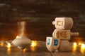 jewish holiday Hanukkah with wooden dreidels colection & x28;spinning top& x29; and gold garland lights on the table Royalty Free Stock Photo