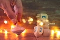 jewish holiday Hanukkah with wooden dreidels colection & x28;spinning top& x29; and gold garland lights on the table Royalty Free Stock Photo