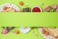 Jewish holiday Passover background with matzo, seder plate and spring flowers