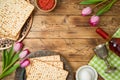 Jewish holiday Passover background with matzo, seder plate, wine and tulip flowers on wooden table Royalty Free Stock Photo