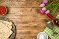 Jewish holiday Passover background with matzo, seder plate, wine and tulip flowers on wooden table Royalty Free Stock Photo