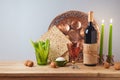 Jewish holiday Passover celebration concept with wine, matzah and seder plate on wooden table over gray background Royalty Free Stock Photo