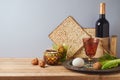 Jewish holiday Passover celebration concept with wine, matzah and seder plate on wooden table over gray background Royalty Free Stock Photo