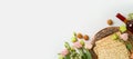 Jewish holiday Passover concept with matzah, seder plate, spring flowers and wine bottle on white background. Top view, flat lay