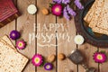 Jewish holiday Passover greeting card with matza and seder plate over wooden background.
