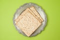 Jewish holiday Passover matzo and seder plate on green background