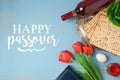 Jewish holiday Passover Pesah greeting card with seder plate, matzoh and tulip flowers on wooden rustic background