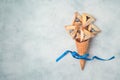 Jewish holiday Purim hamantaschen cookies in waffel cone on rustic background. Top view from above