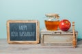 Jewish holiday Rosh Hashana background with chalkboard, honey jar and apple