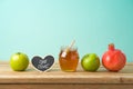Jewish holiday Rosh Hashana background with honey, apple and pomegranate on wooden table Royalty Free Stock Photo