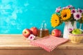 Jewish holiday Rosh Hashana background with honey jar, apples and sunflowers on wooden table. Kitchen counter with tablecloth and Royalty Free Stock Photo