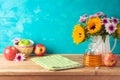 Jewish holiday Rosh Hashana background with honey jar, apples and sunflowers on wooden table. Kitchen counter with tablecloth and Royalty Free Stock Photo