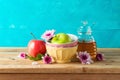 Jewish holiday Rosh Hashana concept with honey jar, apple and flowers on wooden table Royalty Free Stock Photo