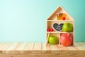 Jewish holiday Rosh Hashana creative decor background with toy house, honey jar, apple and pomegranate on wooden table Royalty Free Stock Photo