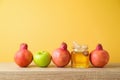 Jewish holiday Rosh Hashanah background with honey, apple and pomegranate on wooden table Royalty Free Stock Photo